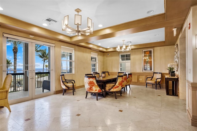 dining room with french doors, a tray ceiling, and an inviting chandelier