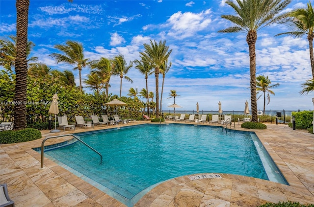 view of pool featuring a water view and a patio area