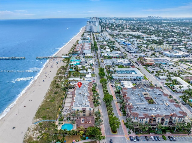 birds eye view of property with a water view and a view of the beach