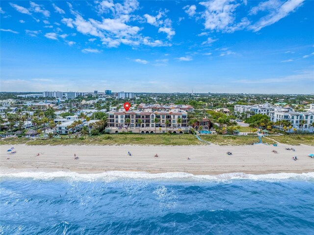 drone / aerial view featuring a water view and a beach view