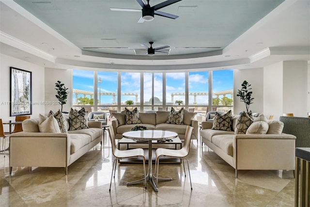 living room featuring a raised ceiling and ceiling fan