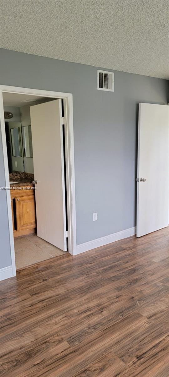 unfurnished room featuring hardwood / wood-style floors and a textured ceiling