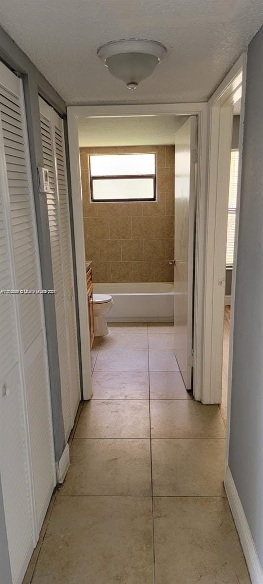 corridor featuring light tile patterned floors