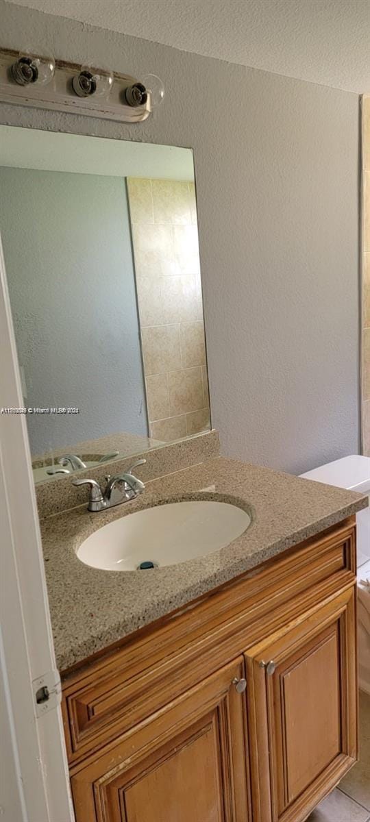 bathroom featuring tile patterned floors, vanity, and toilet