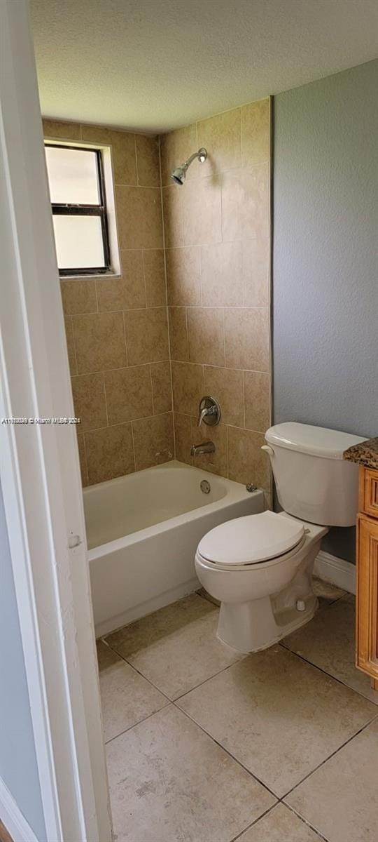 full bathroom with toilet, tile patterned flooring, vanity, and tiled shower / bath