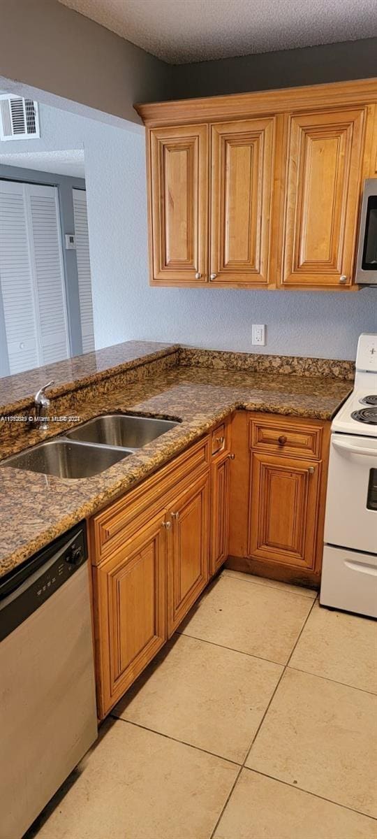 kitchen featuring sink, light tile patterned floors, and stainless steel appliances