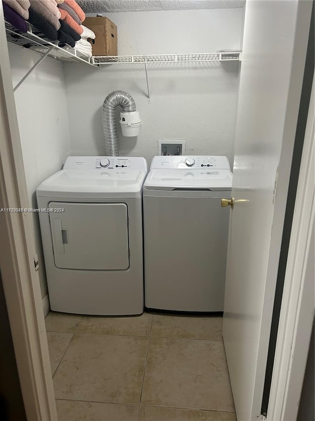 washroom featuring washing machine and clothes dryer and light tile patterned flooring