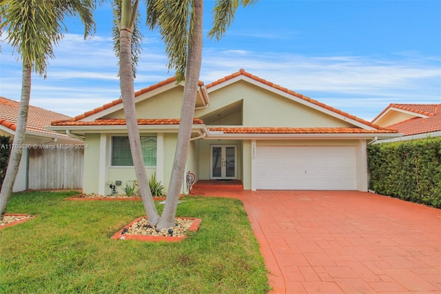 mediterranean / spanish-style house with french doors and a front lawn