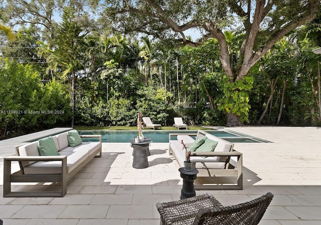 view of pool featuring an outdoor living space and a patio area