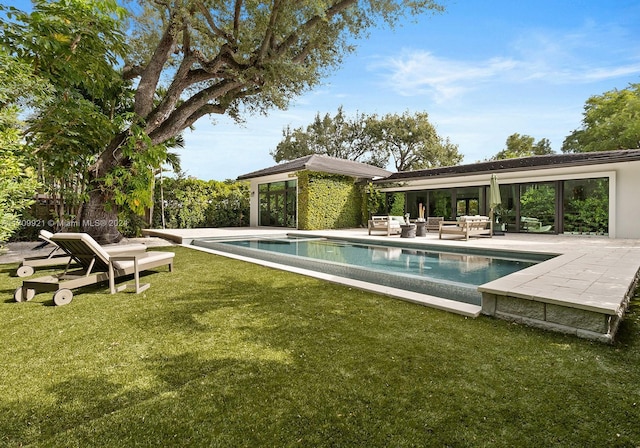 view of swimming pool featuring an outdoor living space, a patio area, and a lawn