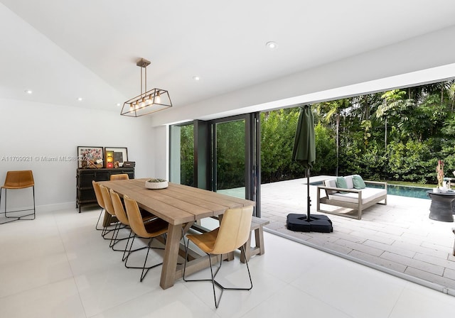 dining space with light tile patterned floors and vaulted ceiling