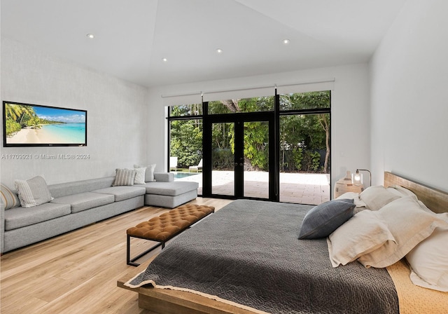 bedroom featuring french doors, lofted ceiling, access to outside, and light hardwood / wood-style floors