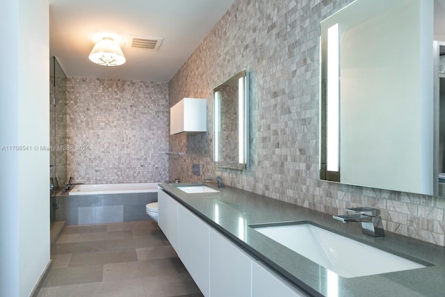 bathroom featuring vanity, backsplash, toilet, tile walls, and tiled bath