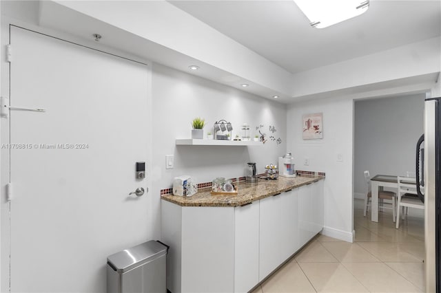 3901 S Ocean Dr Unit 15N, Hollywood, FL 33019 - kitchen featuring freestanding refrigerator, white cabinetry, light tile patterned flooring, stone counters, and recessed lighting