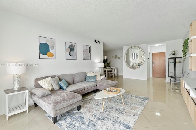 tiled living room featuring a textured ceiling