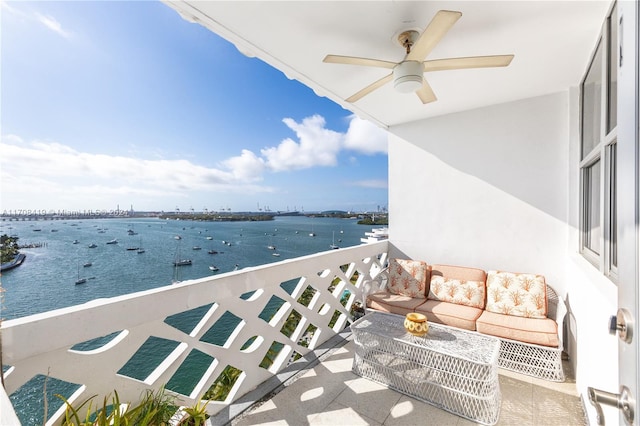 balcony featuring an outdoor living space and a water view