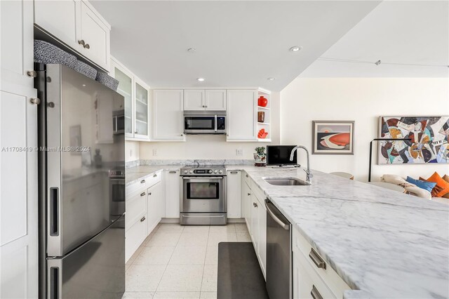 kitchen featuring light stone counters, sink, white cabinets, and appliances with stainless steel finishes