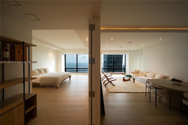 bedroom with hardwood / wood-style flooring and expansive windows