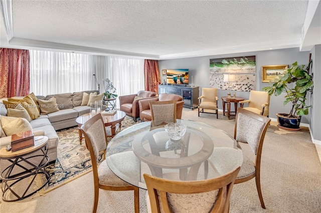 dining room featuring a textured ceiling, light carpet, and baseboards