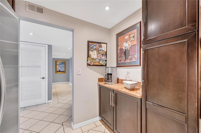 bar featuring light tile patterned flooring, a sink, recessed lighting, baseboards, and visible vents