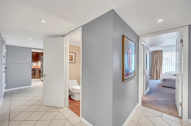 hallway with baseboards, light carpet, recessed lighting, and light tile patterned flooring