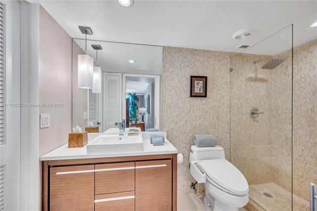 full bath with visible vents, a tile shower, vanity, a closet, and toilet