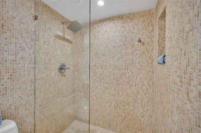 room details featuring recessed lighting, a tile shower, and toilet