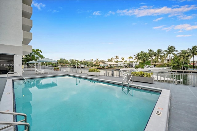 view of pool with a water view and a patio