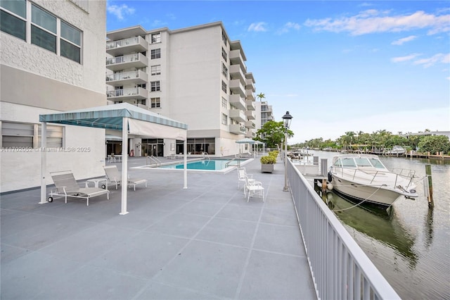 view of patio with a community pool and a water view