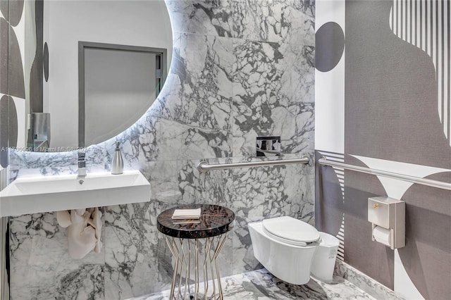 bathroom featuring toilet, tile walls, and sink