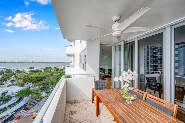 balcony featuring a water view and ceiling fan