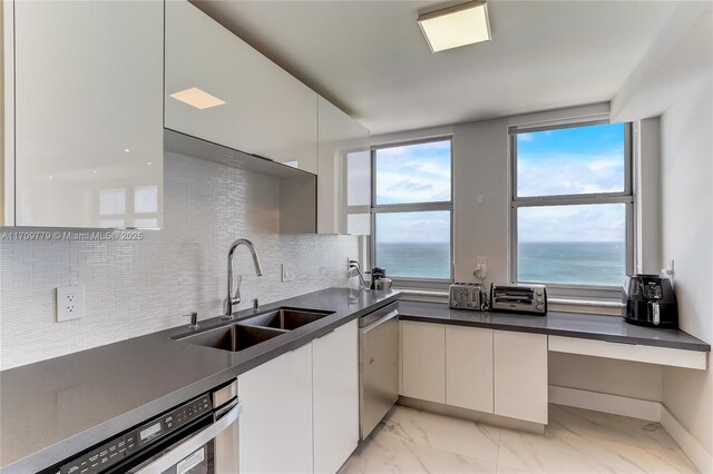 kitchen featuring a water view, white cabinetry, wall chimney exhaust hood, and appliances with stainless steel finishes