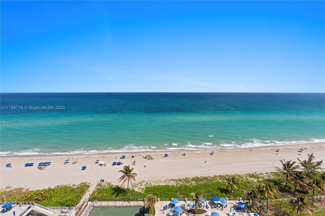 birds eye view of property featuring a water view and a beach view