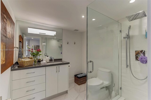 bathroom with walk in shower, vanity, and toilet