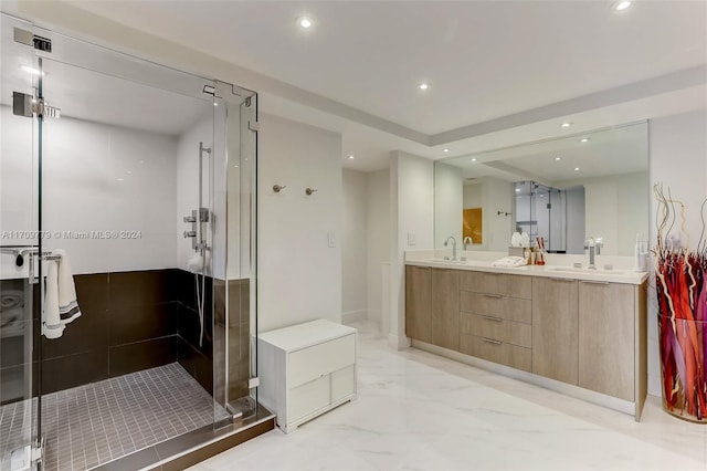 bathroom with a shower with door and vanity