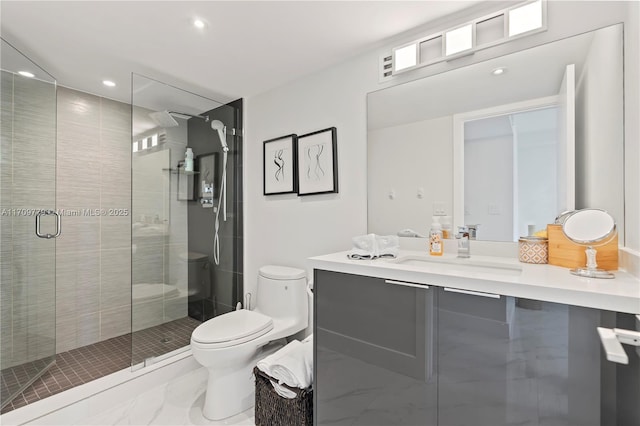 bathroom featuring vanity, a shower with shower door, and toilet