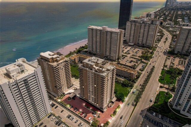 aerial view at dusk with a beach view and a water view