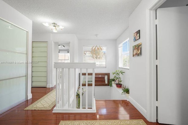 hallway with wood-type flooring and a textured ceiling