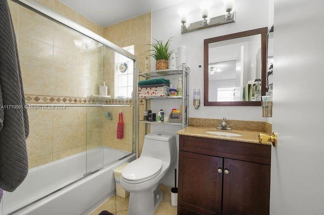 full bathroom with toilet, tile patterned flooring, vanity, and combined bath / shower with glass door