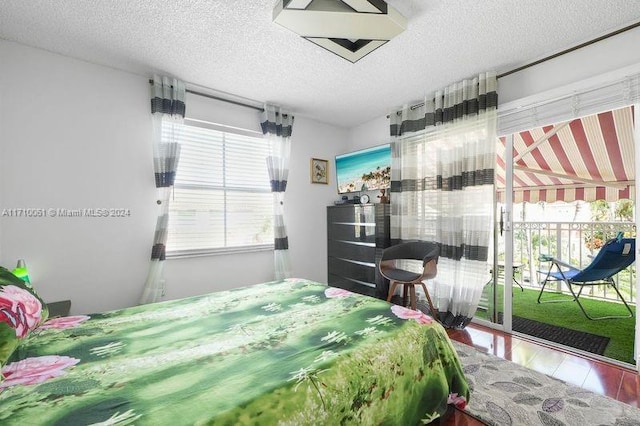 bedroom featuring access to exterior and a textured ceiling