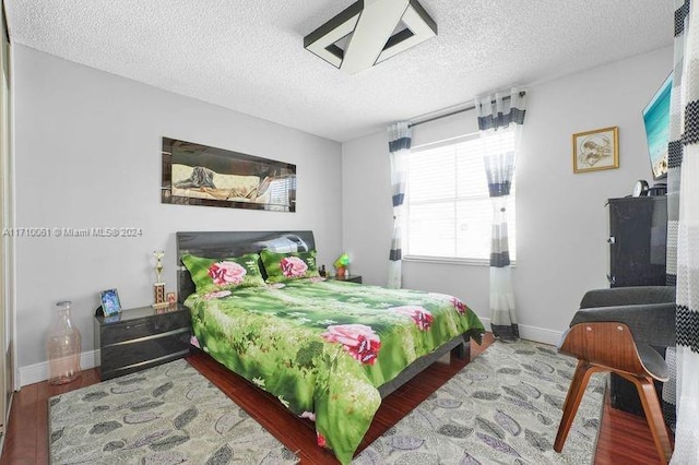 bedroom with hardwood / wood-style flooring and a textured ceiling