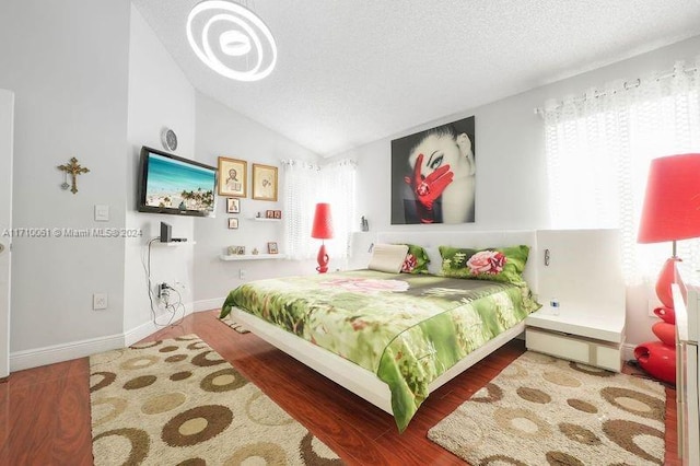 bedroom featuring wood-type flooring, a textured ceiling, a baseboard heating unit, and lofted ceiling