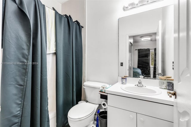 bathroom featuring a shower with curtain, vanity, and toilet