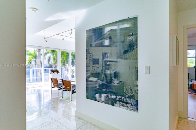 corridor featuring light tile patterned floors and a wealth of natural light