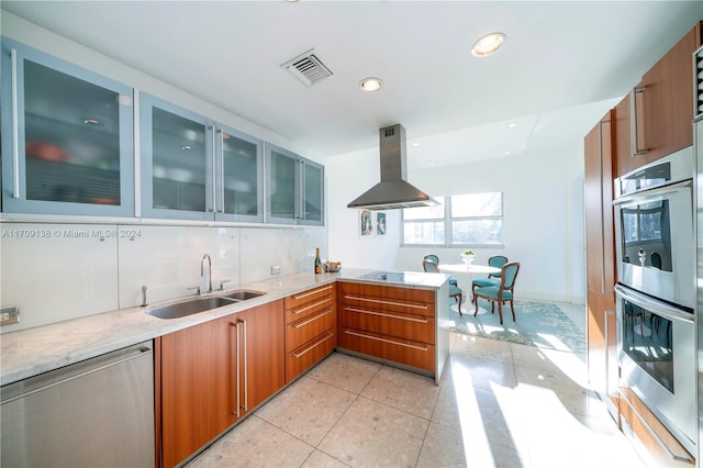 kitchen featuring sink, light tile patterned floors, appliances with stainless steel finishes, island range hood, and kitchen peninsula