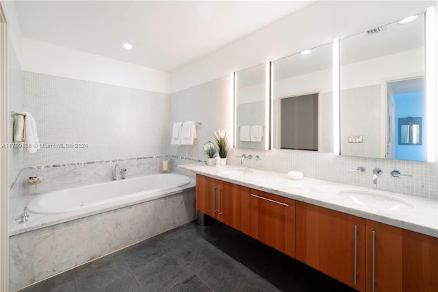 bathroom with tile patterned flooring, vanity, backsplash, and tiled tub