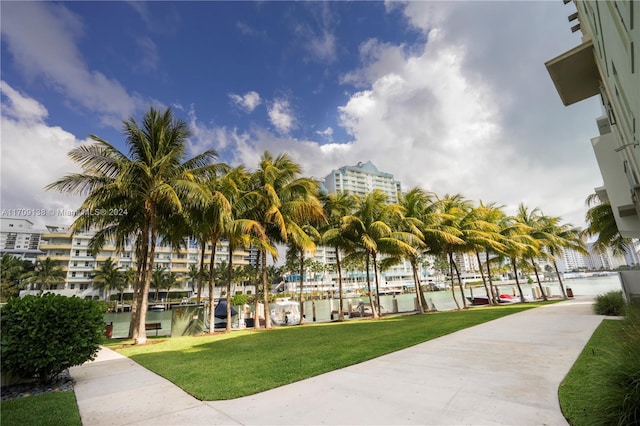 view of property's community featuring a lawn and a water view