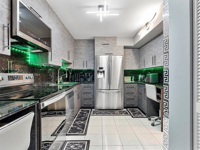 kitchen with light tile patterned flooring, appliances with stainless steel finishes, and sink