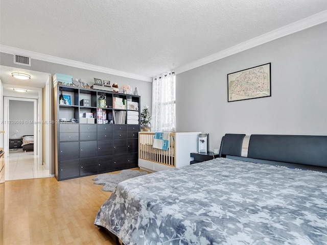 bedroom featuring hardwood / wood-style floors, a textured ceiling, and ornamental molding