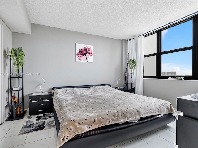 bedroom with light tile patterned floors and a textured ceiling